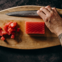 Person preparing salmon on a wooden board Person preparing salmon on a wooden board