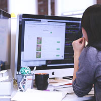 woman looking at desktop screen woman looking at desktop screen