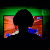 person sitting in front of a screen playing video games person sitting in front of a screen playing video games