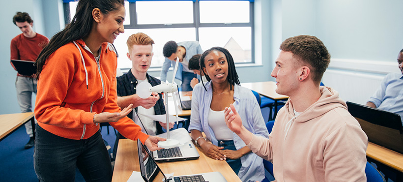 Students chatting with each other in a classroom Students chatting with each other in a classroom