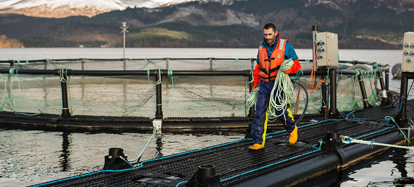 Man walking around a fish farm Man walking around a fish farm