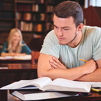 Student sat in Library reading books and working Student sat in Library reading books and working