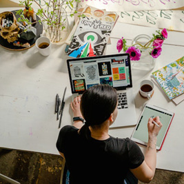 Person uysing a drawing tablet whilst using a laptop Person uysing a drawing tablet whilst using a laptop
