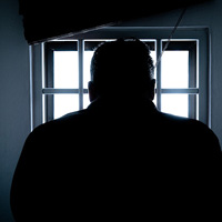Shadow of man looking out of prison window Shadow of man looking out of prison window