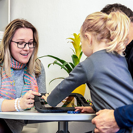 Woman showing a book to a child and man Woman showing a book to a child and man