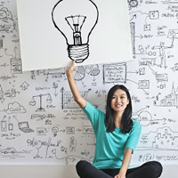 Woman holding up a drawing of a light bulb to signify an idea Woman holding up a drawing of a light bulb to signify an idea