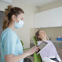Nurse using a tablet device near a patient Nurse using a tablet device near a patient