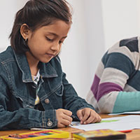 Girl at school drawing with crayons Girl at school drawing with crayons