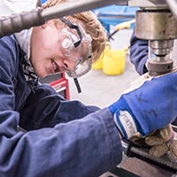 Student wearing PPE doing metalwork Student wearing PPE doing metalwork