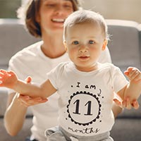 Childcare provider helping toddler stand up Childcare provider helping toddler stand up
